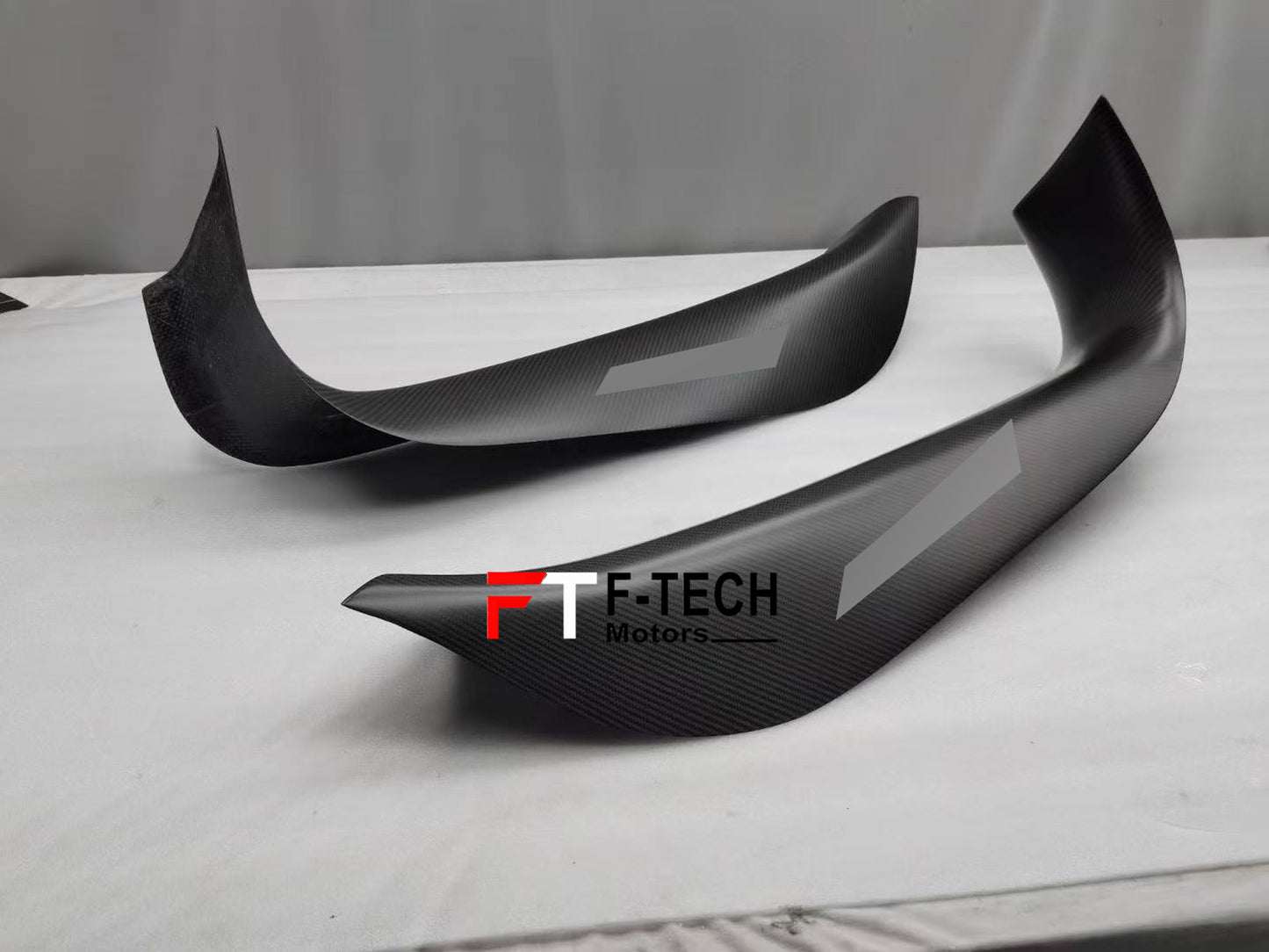Carbon fiber car spoilers with F-Tech Motors branding on a gray background