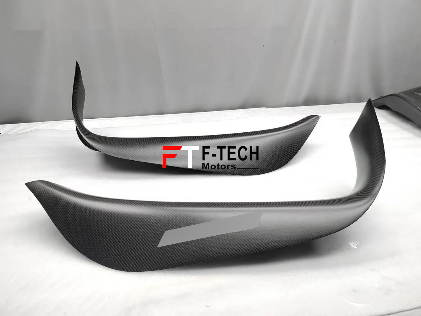 Carbon fiber car wrap with F-Tech Motors logo on a vehicle surface
