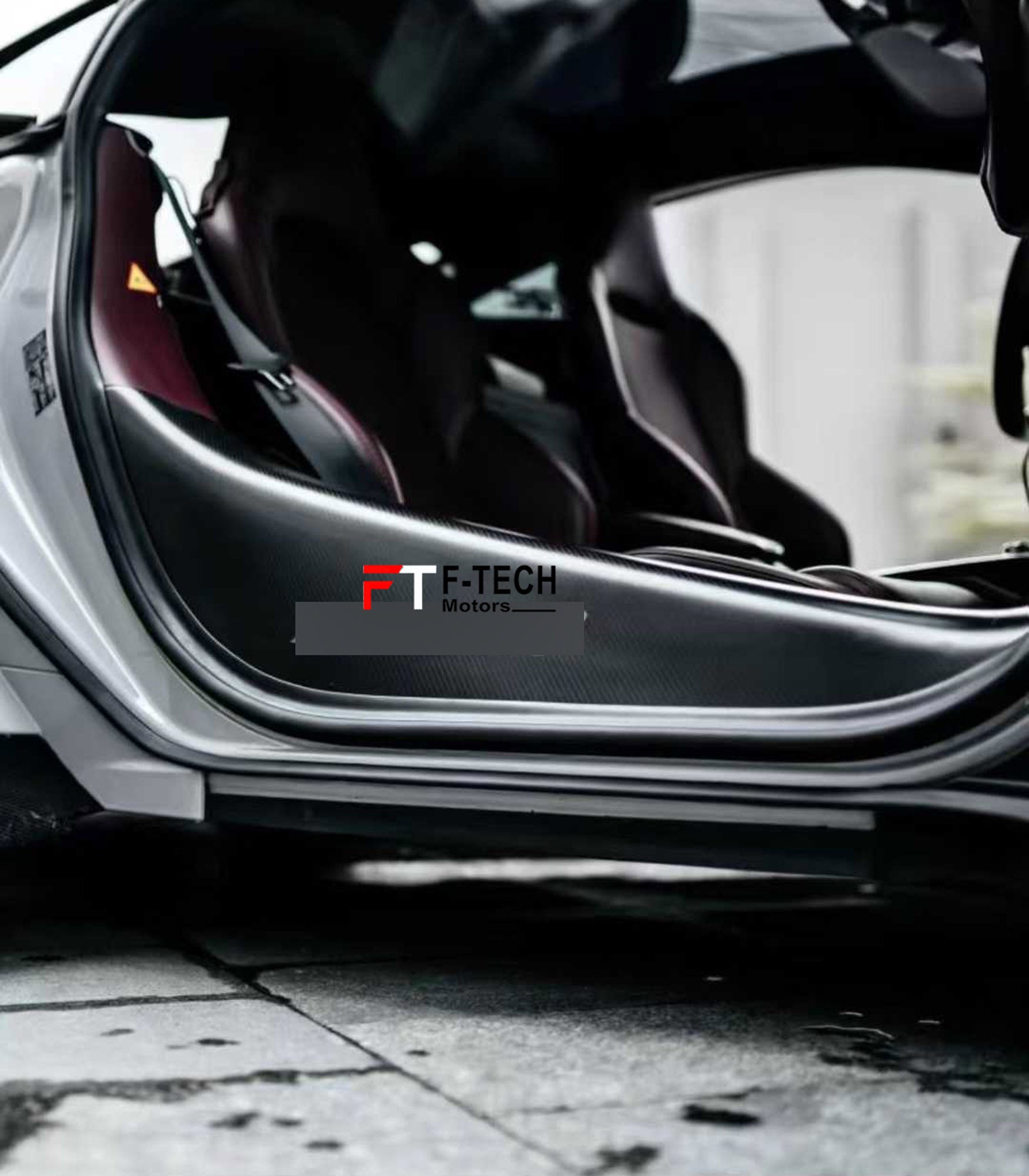 Carbon fiber car wrap with F-Tech Motors logo on a vehicle surface